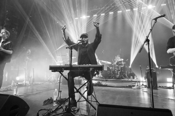 A black and white shot of a band performing on stage