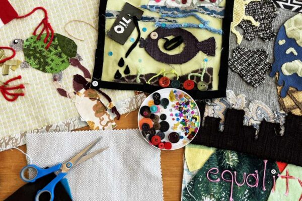 A spread of various textiles and crafts on a table.