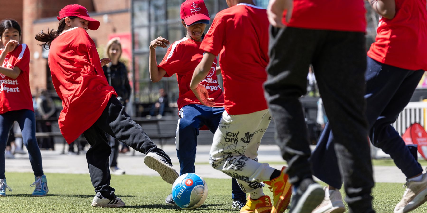 A group of kids playing soccer on an outdoor pitch