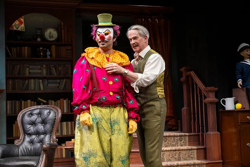 Two men talking, one dressed as clown