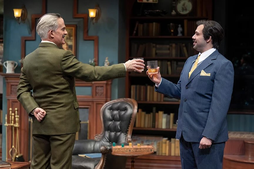 Two men in suits toasting a drink
