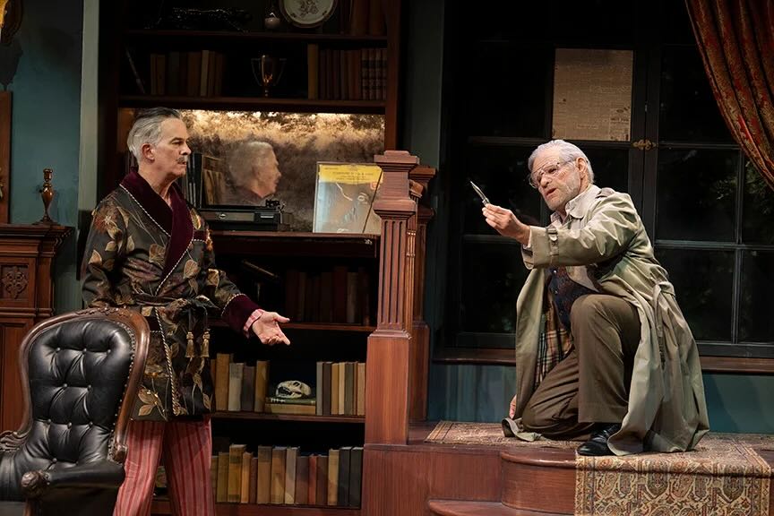 Two men talk on stage.