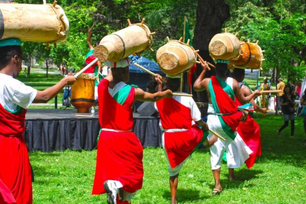A line of drummers wearing bright red attire