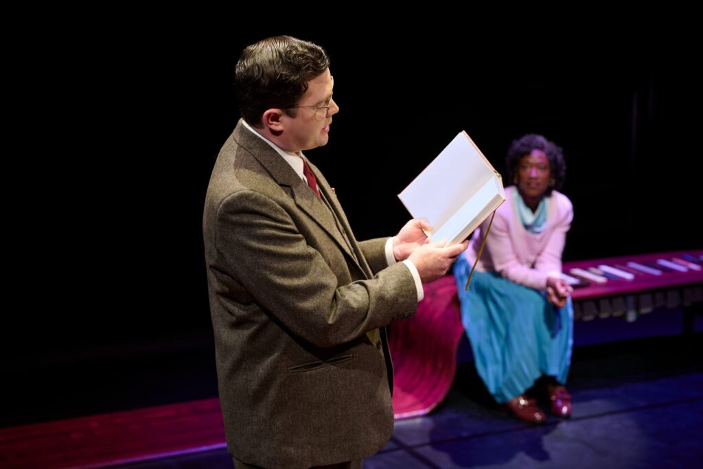 Two actors on a stage in performance.