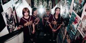 A group of four artists posing on a stairwell.