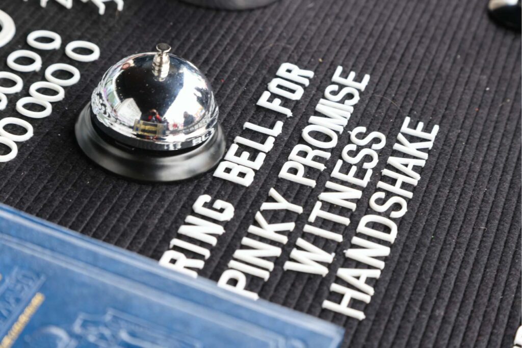 A close-up image of a bell on a sign board with words.