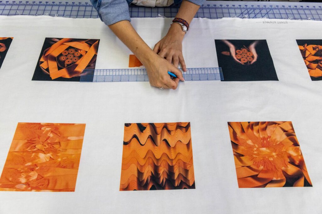An artist holding orange ribbons working on an installation project