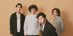 A group of four artists posing against a plain background.