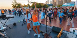 A crowd dancing with dance instructors outdoors