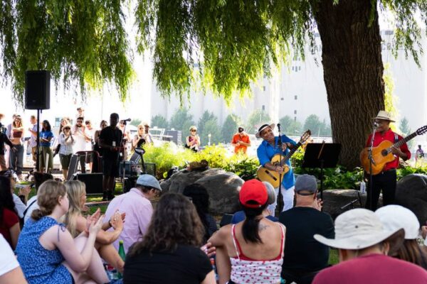 Artists performing to a crowd at a garden
