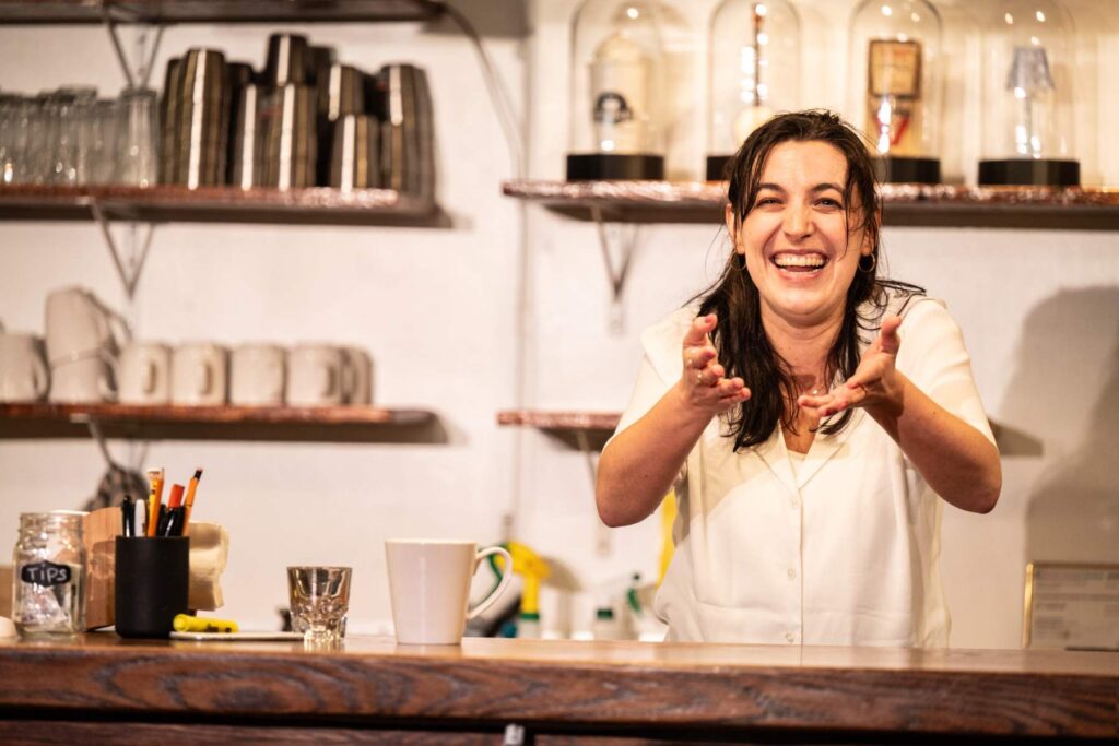 Woman performing in a cafe on stage in front of a theatre audience